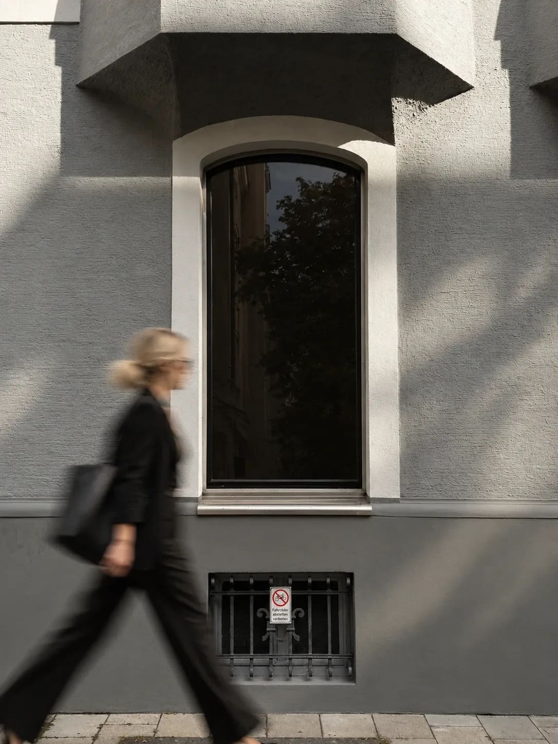 Person geht an einer Münchner Altbaufassade in Schwabing vorbei (KI-generiert)